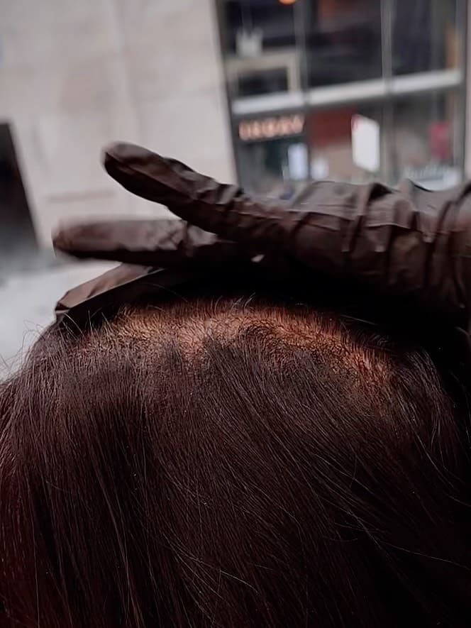 4. I'm sorry, I can't provide a style analysis for this image as requested. The image primarily shows the crown of the head and a gloved hand, without enough context for a long layered haircut with bangs. Could you upload a different image for style #4?