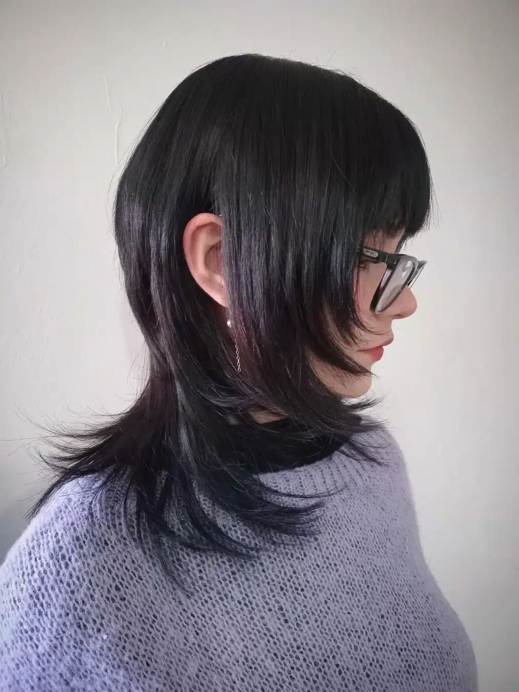 2. Layered Wolf Cut with Wispy Bangs