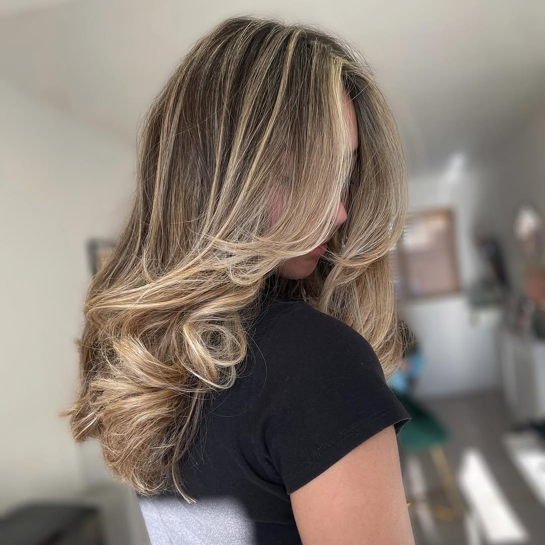 2. Voluminous Face-Framing Layers with Soft Blonde Highlights